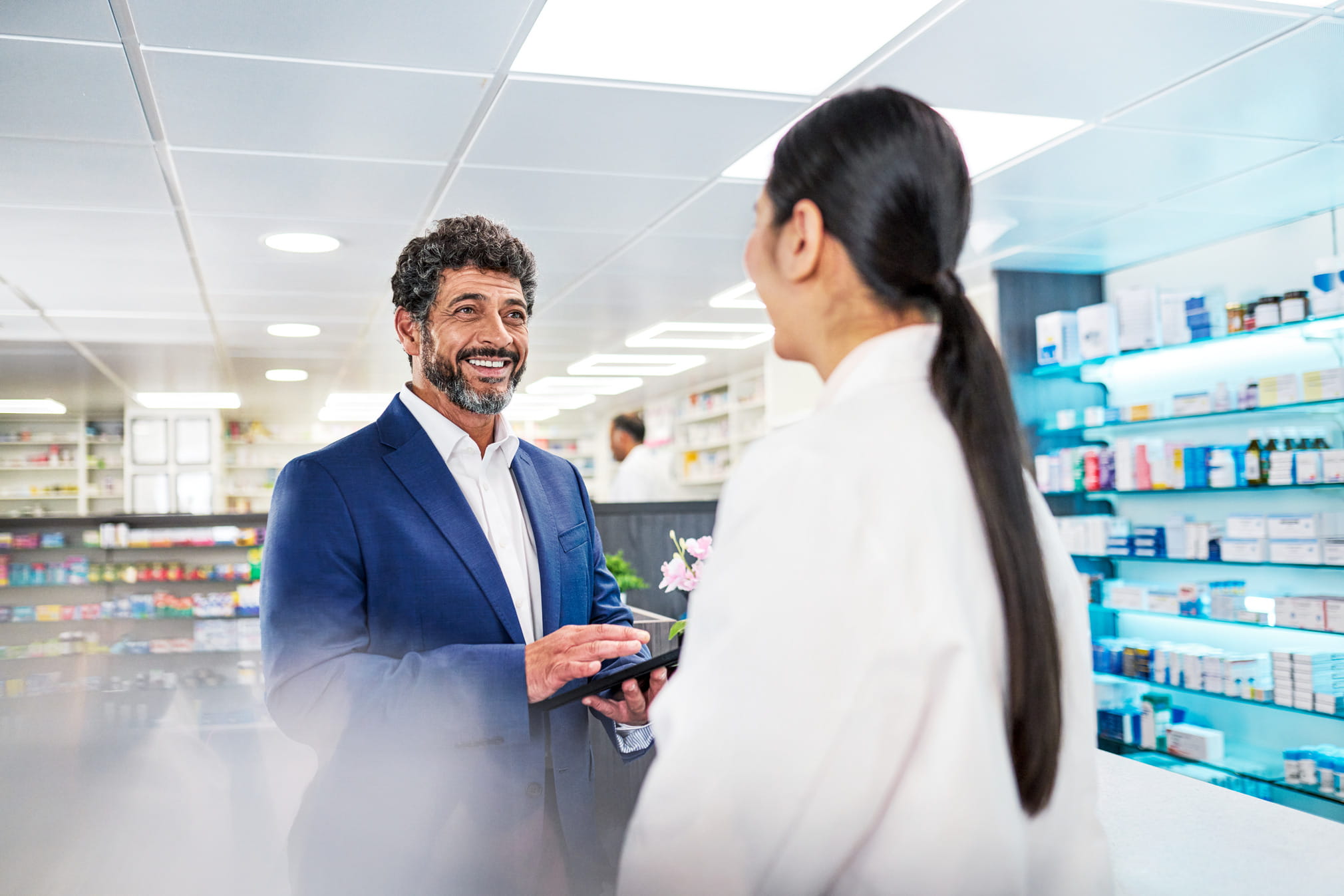 Pharmacy worker is talking with business person