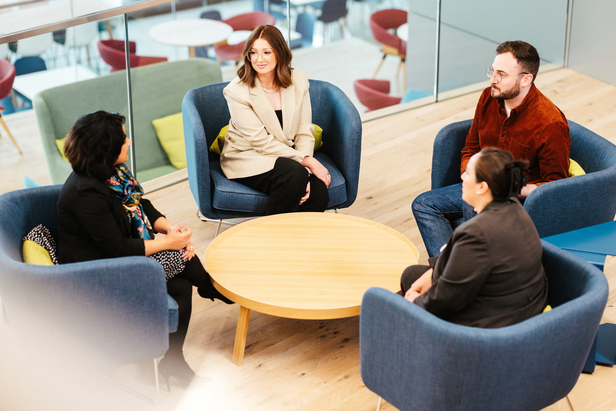 A high angle photo of four Cencora team members sitting around a table talking to each other.