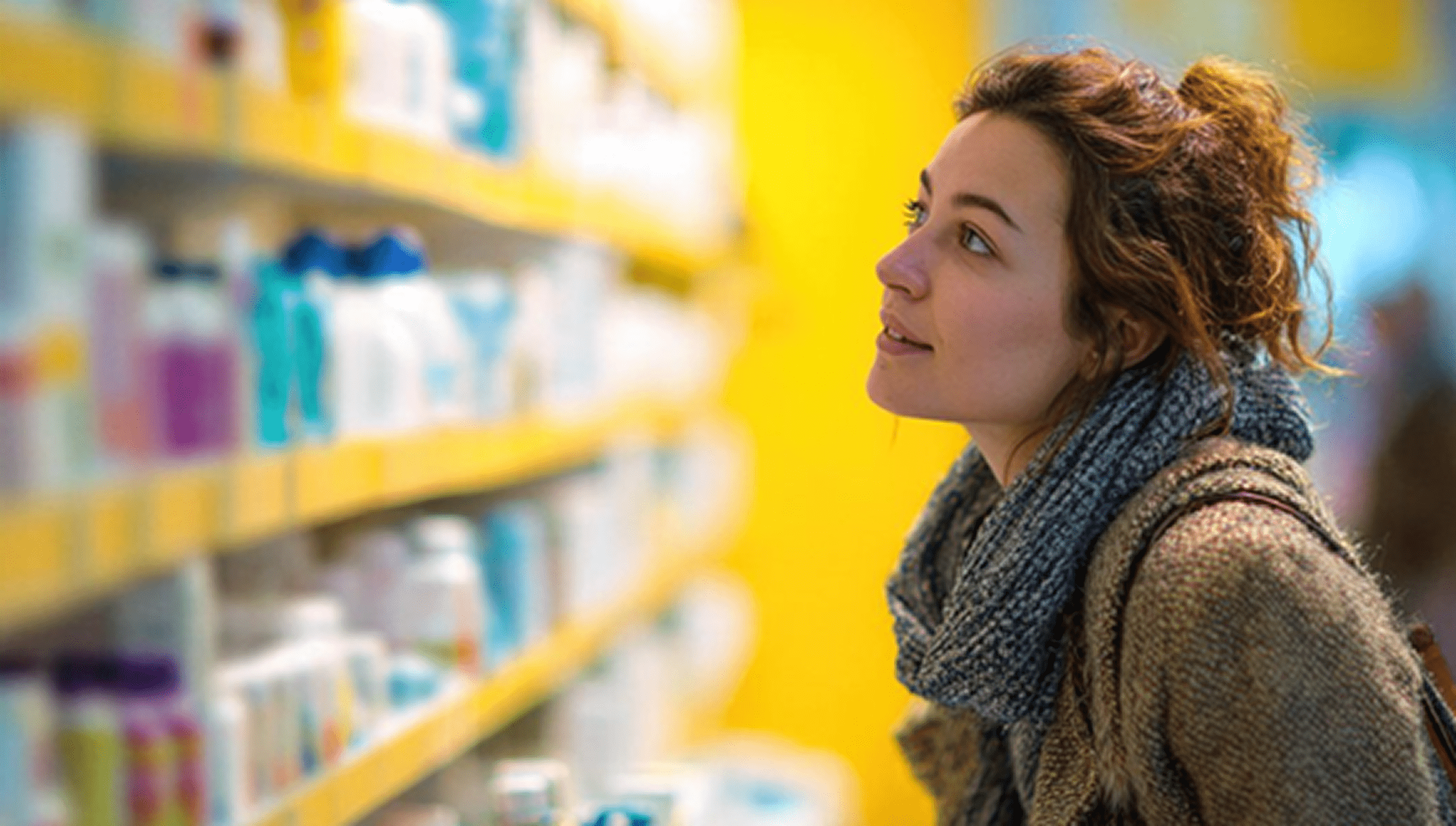 Young woman looking at the pharmacy shelves 