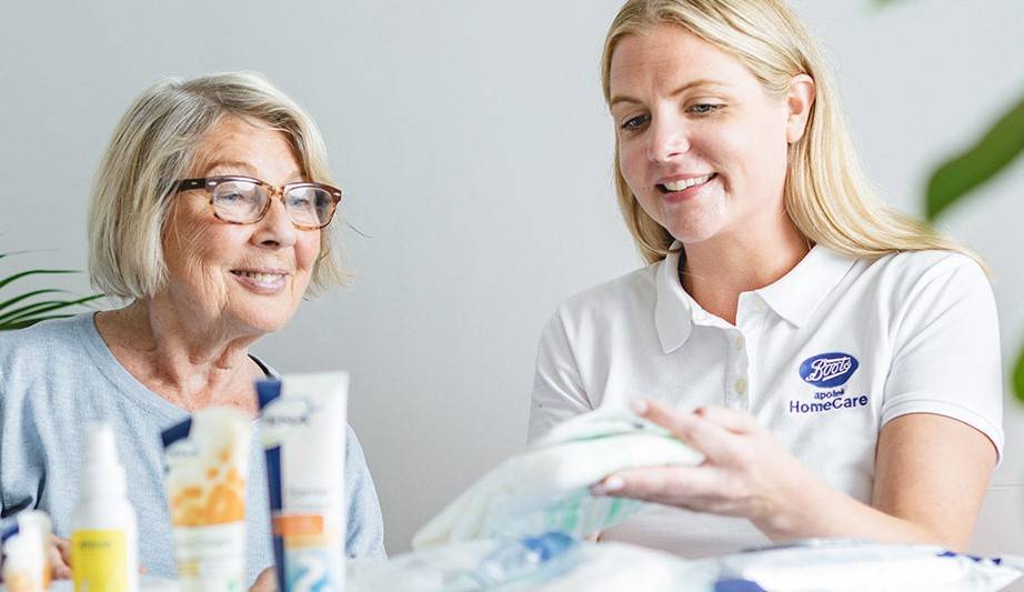 Young woman from Boots Homecare showing medical equipment to older woman