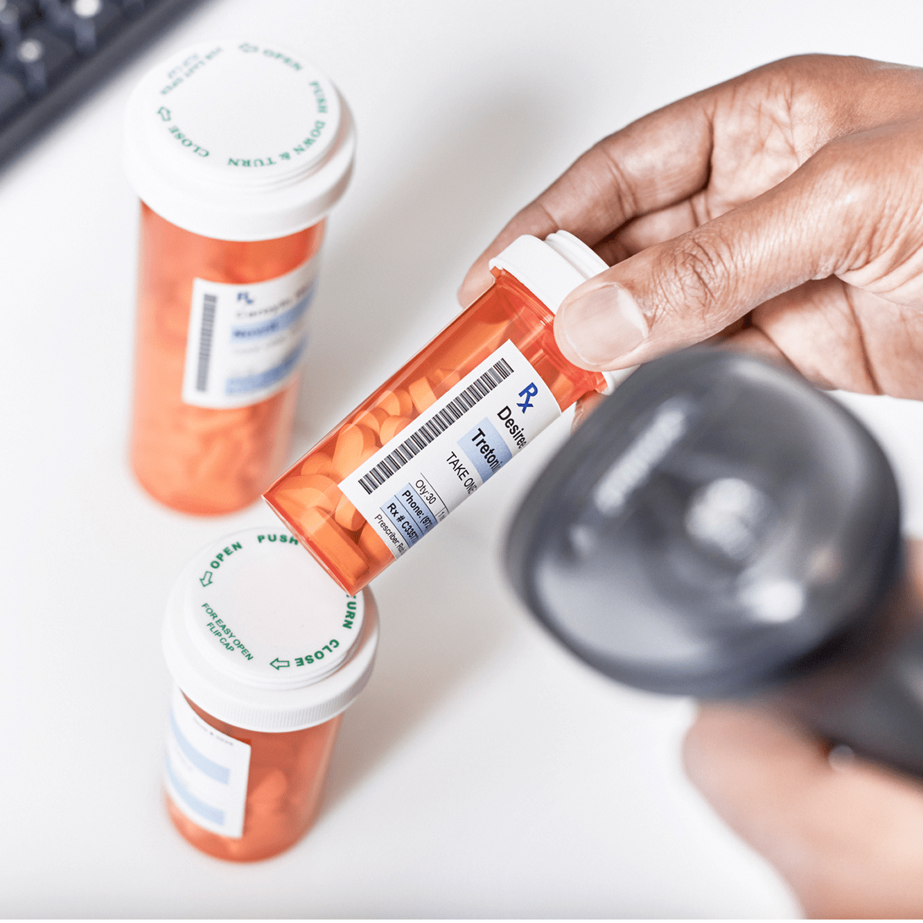 Close-up of pharmaceutical products being scanned at a pharmacy counter.