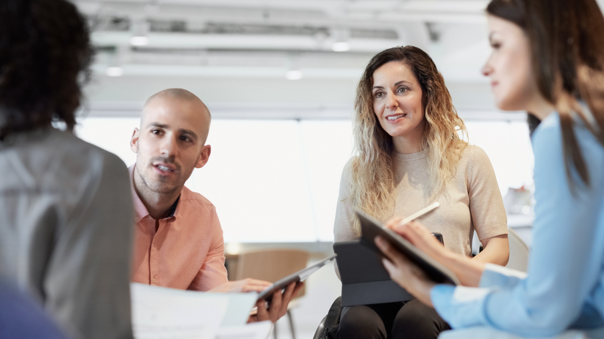 Un groupe de quatre employés de bureau participe à une réunion sur le lieu de travail.