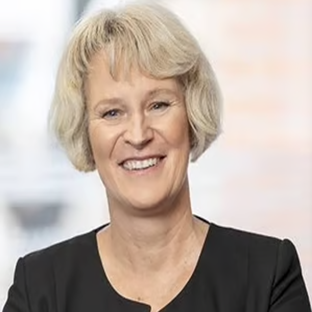 A headshot of a Senior Director at Cencora, a mature aged woman with short blonde hair, and a bright smile, dressed in a black top conveying leadership and professionalism.