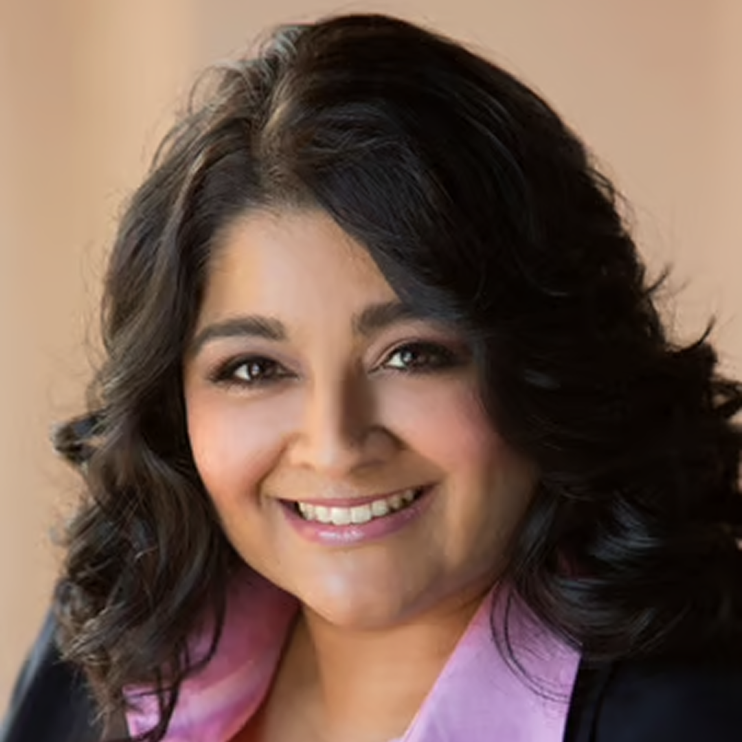 A confident headshot of a senior director at Cencora, a middle-aged woman with short black hair and a slight smile, dressed in a crisp white shirt and dark jacket, conveying leadership and professionalism.