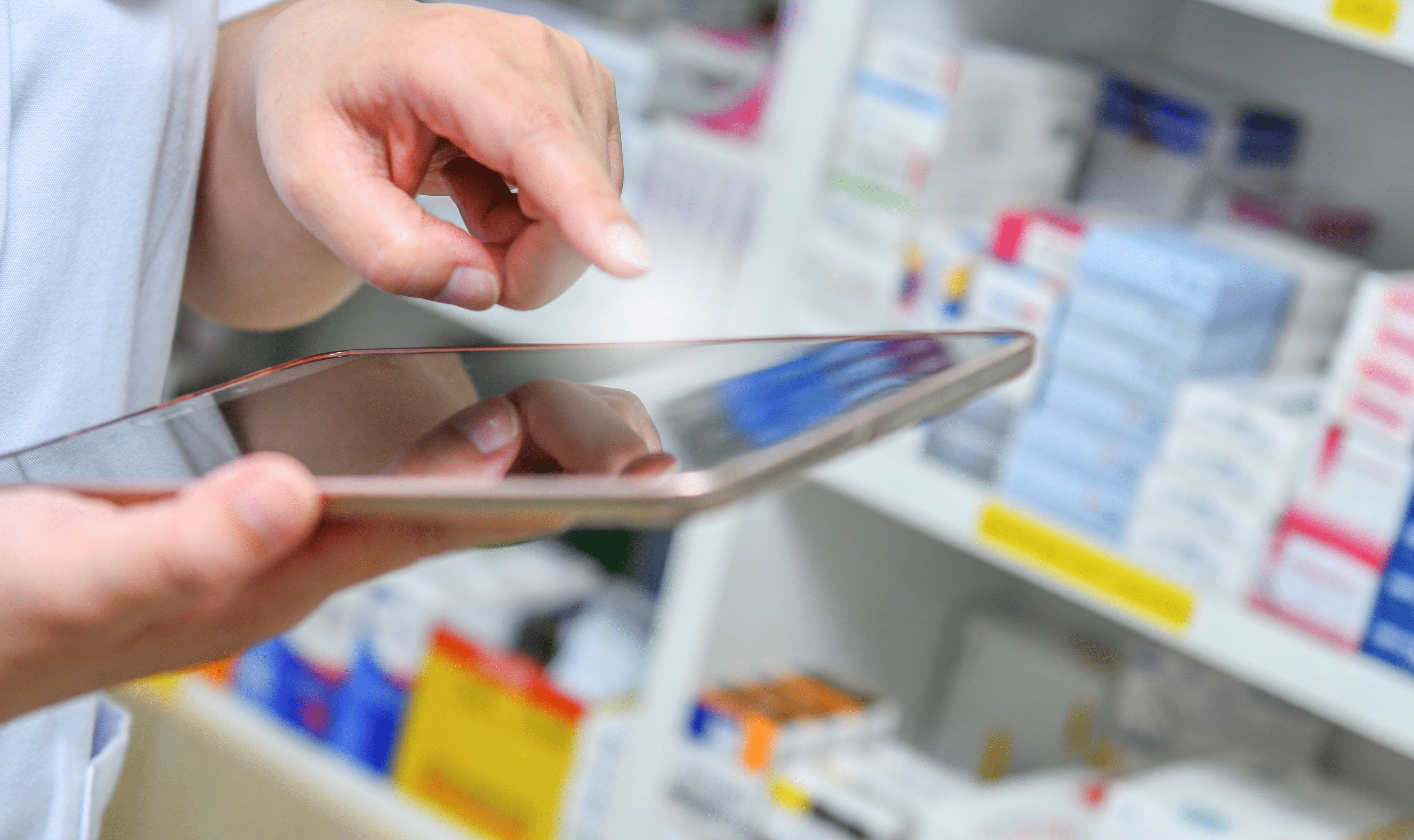 A pharmacist using a tablet to take inventory of his pharmacy