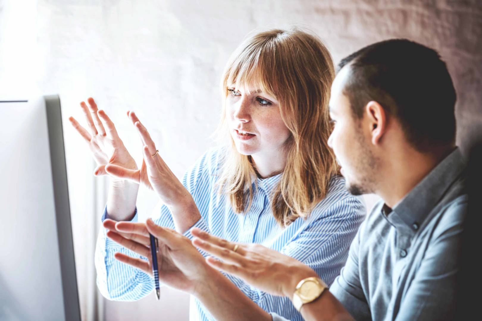 Two business colleagues problem-solving at a computer together in the office.