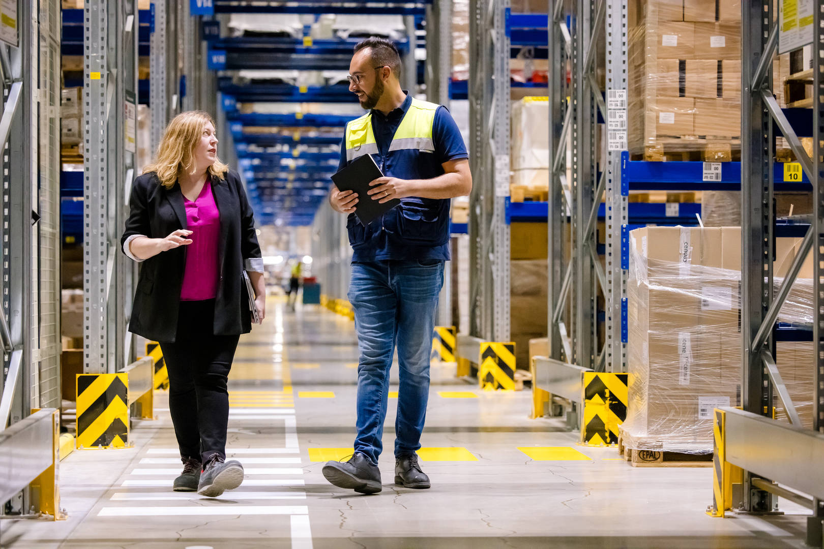 Two employees talk in a distribution center in Spain