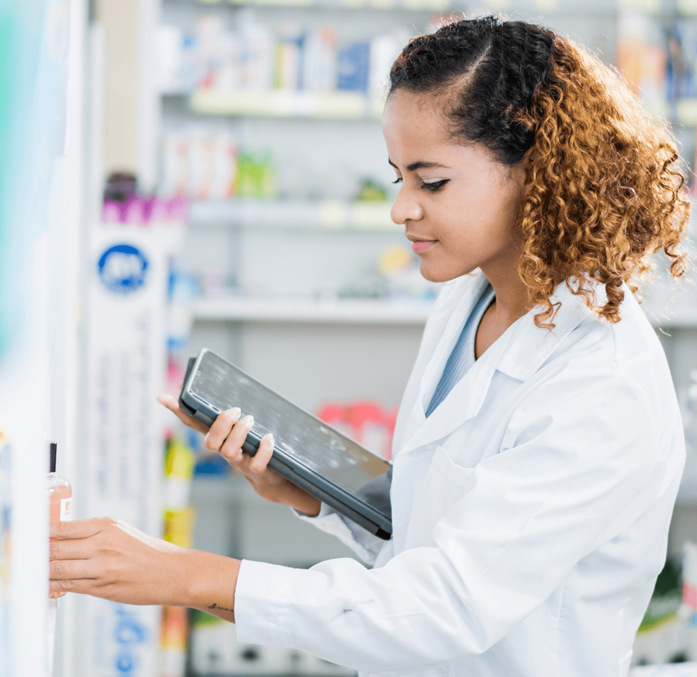 Pharmacy worker looking at the inventory with the tablet in her hands