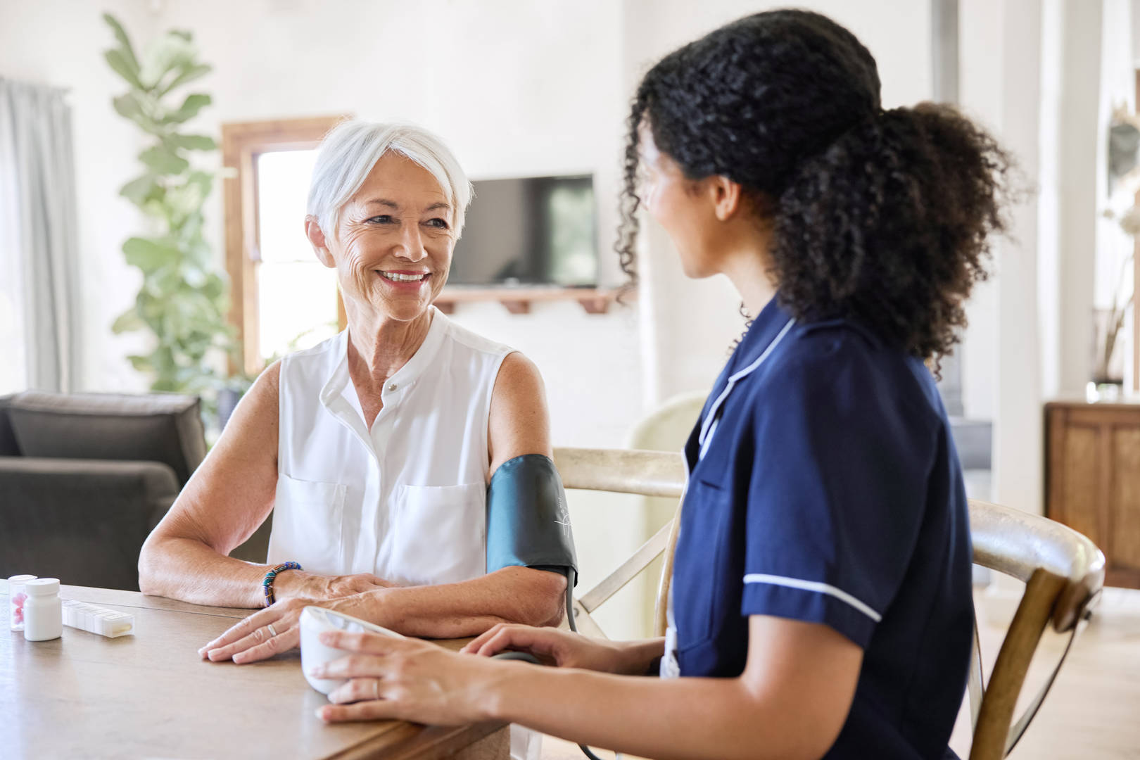 Nurse visits an elderly woman in her home.