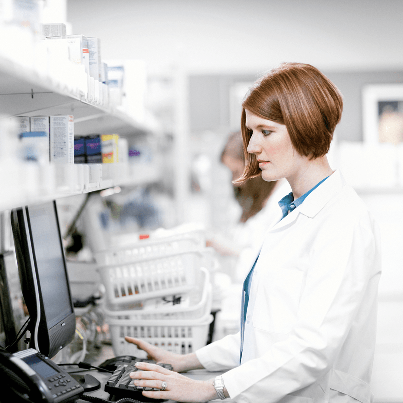woman with white doctors coat working at the computer