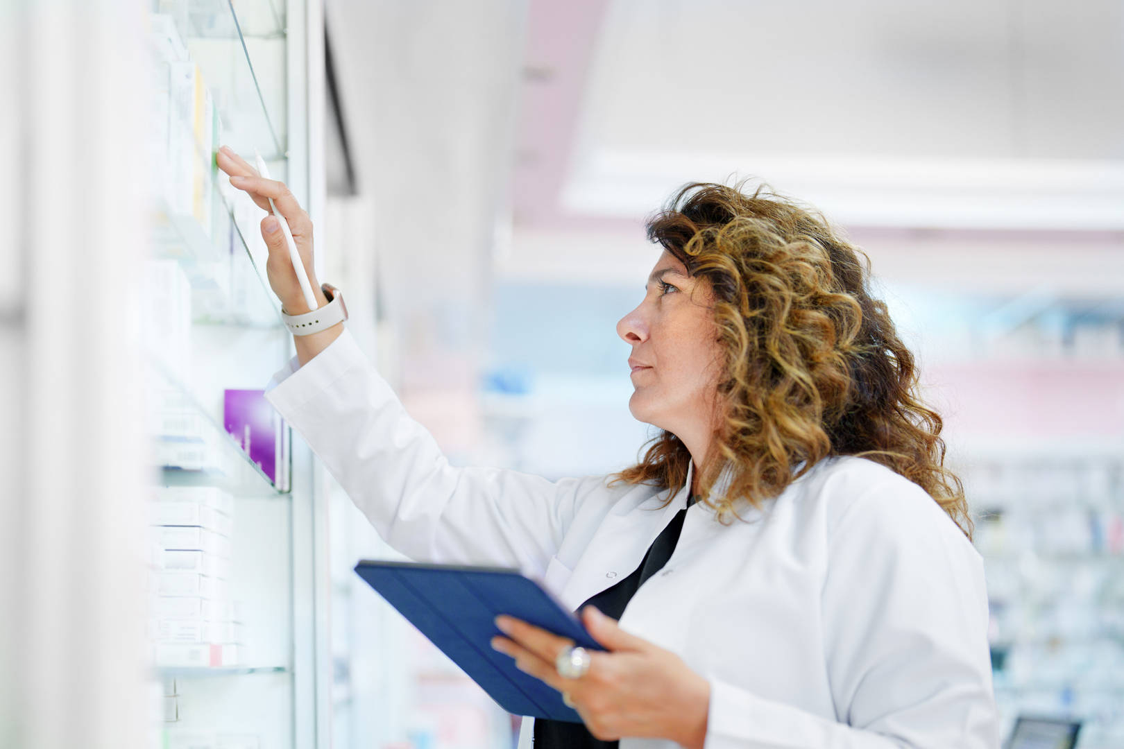 Specialty pharmacist working and grabbing a drug from a shelf